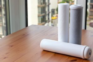 Filter cartridges for drinking water purification for on a wooden table against a blurred background with copy space. Water filtration RO (reverse osmosis) system in Mango, FL