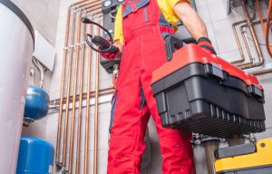 Residential Furnace System Technician at Work. Check and Repair HVAC Systems. Worker with His Toolbox. Industrial Theme in Brandon FL