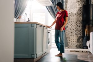 Young hispanic woman using dishwasher while doing housework at home in Lithia, FL